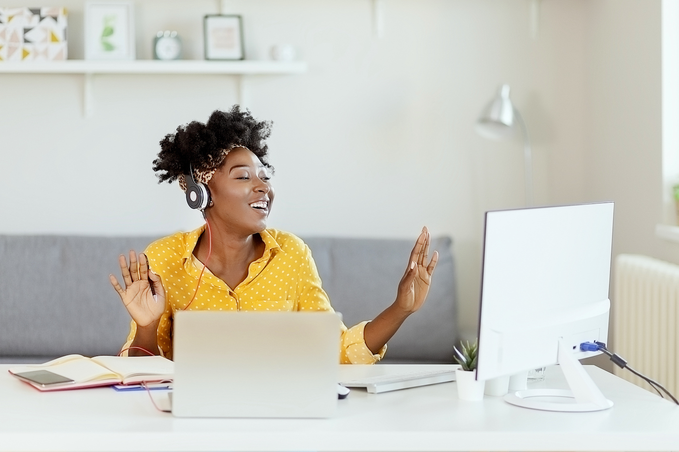 IT agent happily working at her remote workstation, celebrating the ease of IT support by tracking KPIs to conquer complexity