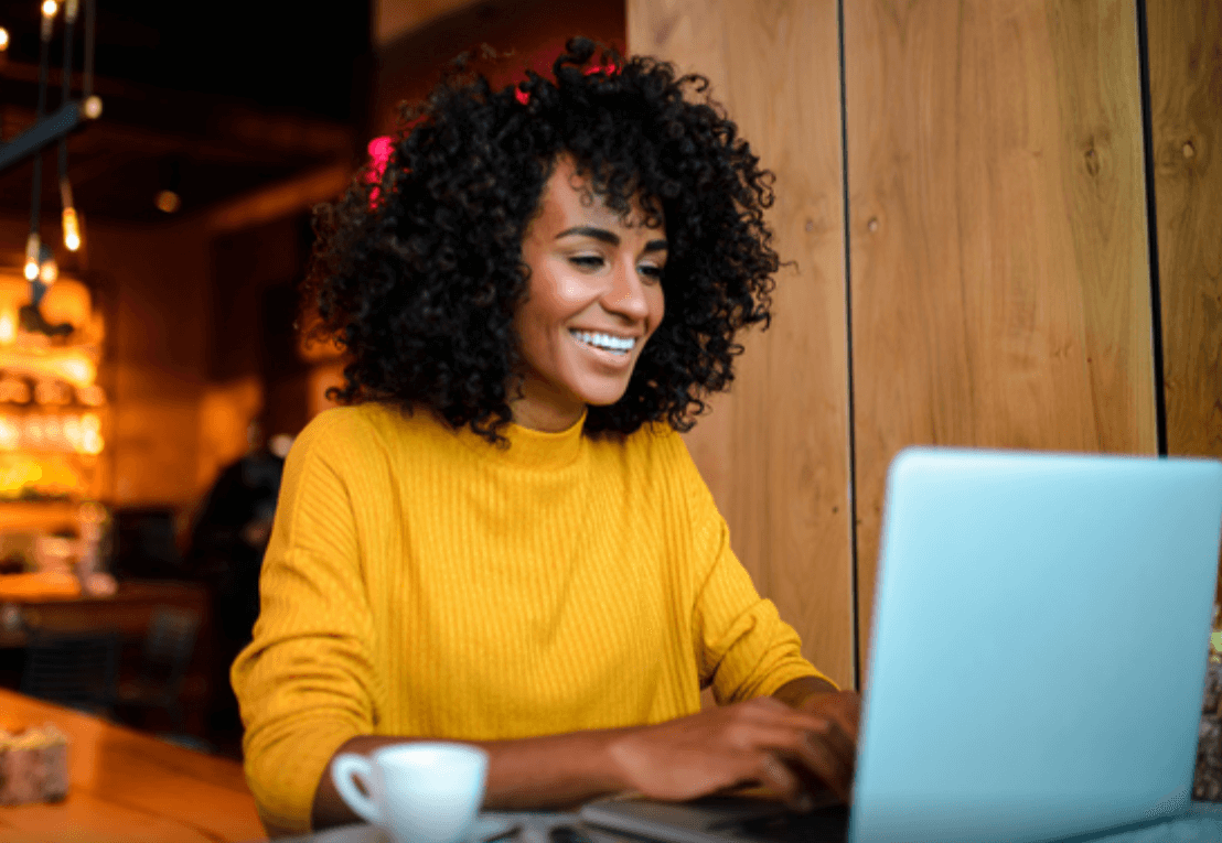 Mujer sonriente trabajando en un portátil.