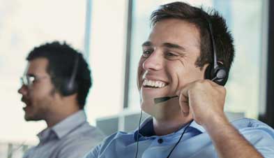 Customer service representative laughing while using GoToConnect with headset